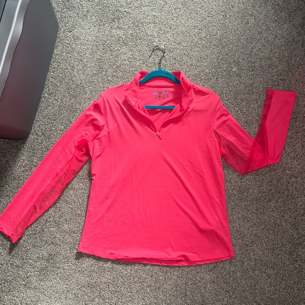 Vibrant coral athletic half zip with mesh on sleeves.